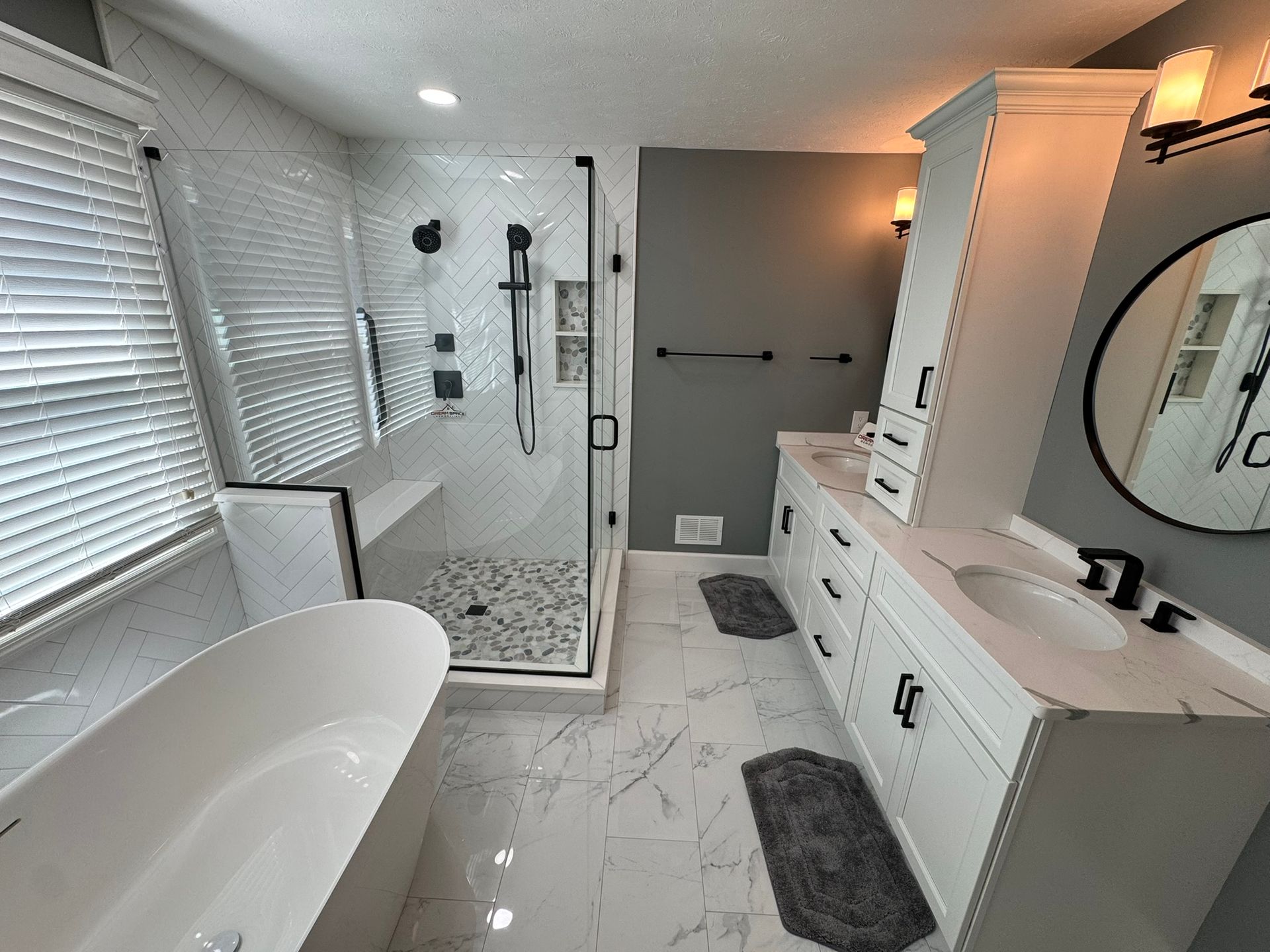 Modern master bathroom in Columbia, MD with glass walk-in shower, freestanding tub, and double vanity.