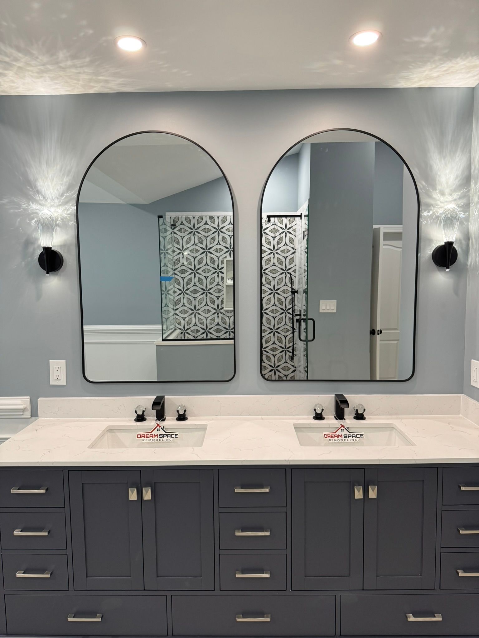 Elegant master bath featuring arch mirrors, quartz countertops, and modern walk-in shower with bench – Perry Hall Maryland
