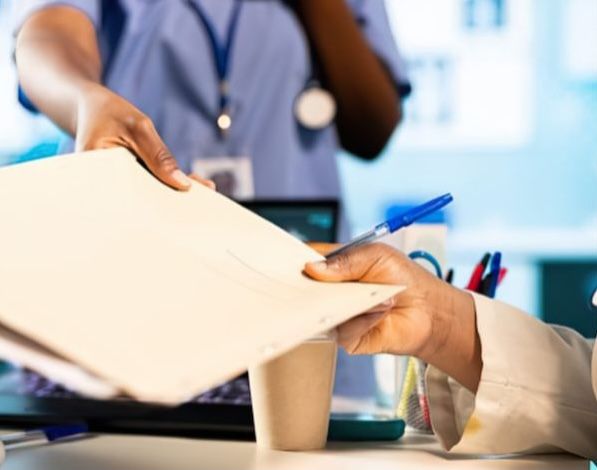 Doctor handing files to caregiver
