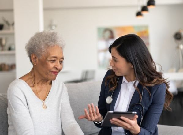 Aide or nurse speaking with a senior at home