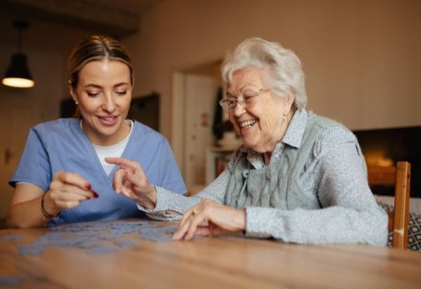 Aide and elderly woman doing a puzzle