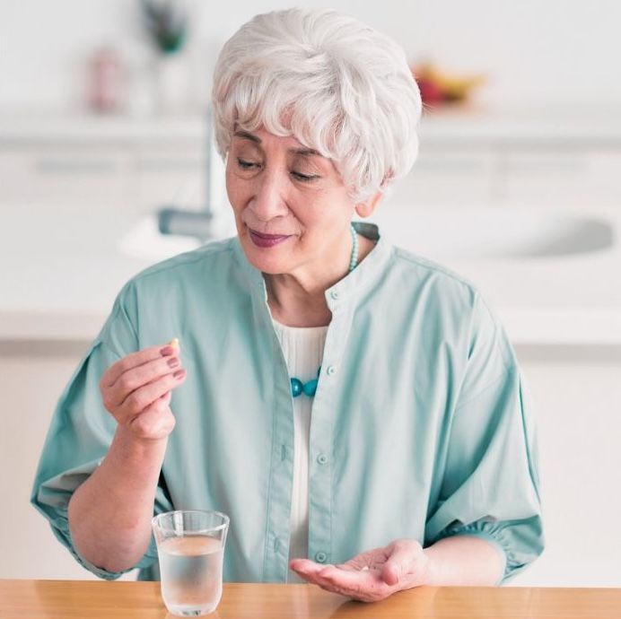 older woman looking at medication