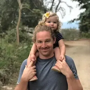 Caston Richards holding his young daughter on his shoulders, representing the next generation of Napa Valley winemakers.