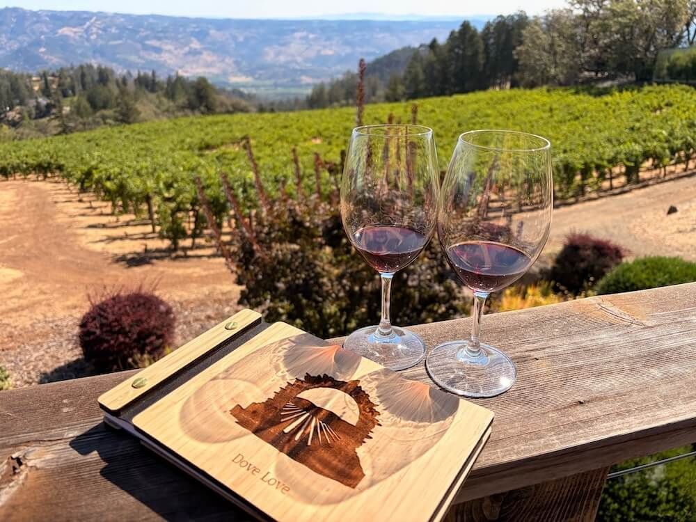Couple enjoying a quiet Napa Valley romantic getaway on a vineyard deck overlooking Spring Mountain.
