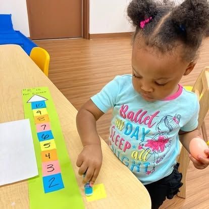 A little girl wearing a blue shirt that says ballet on day sleep all night