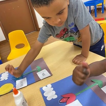 A boy wearing a shirt that says blue is sitting at a table
