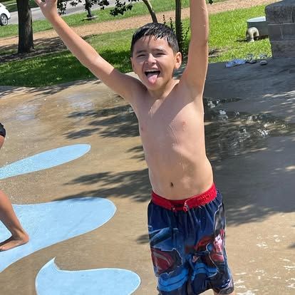 Kid enjoying summer fun at a splash pad.