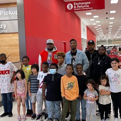 A group of children and adults are posing for a picture in a store.