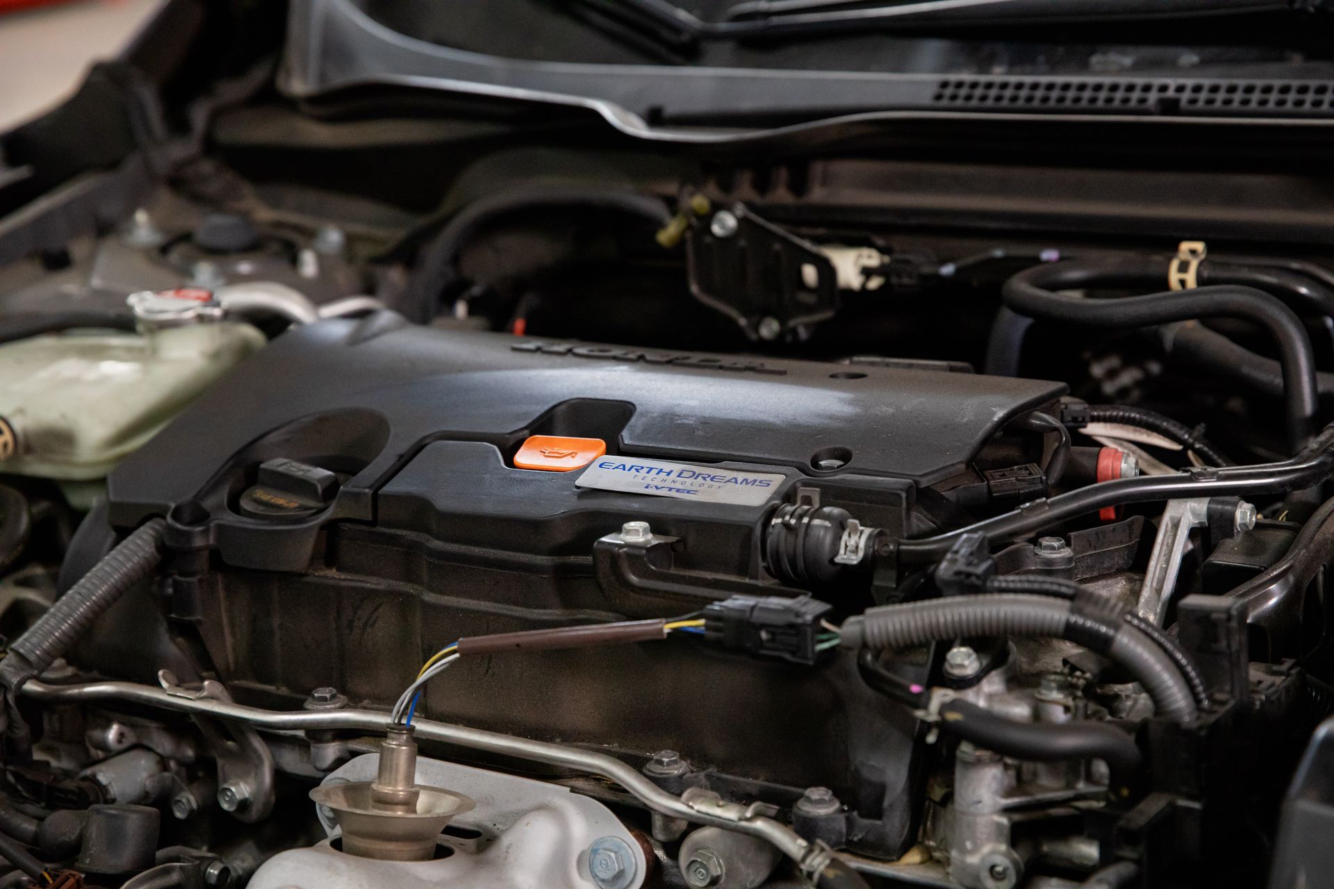 A close up of a car engine with the hood open.