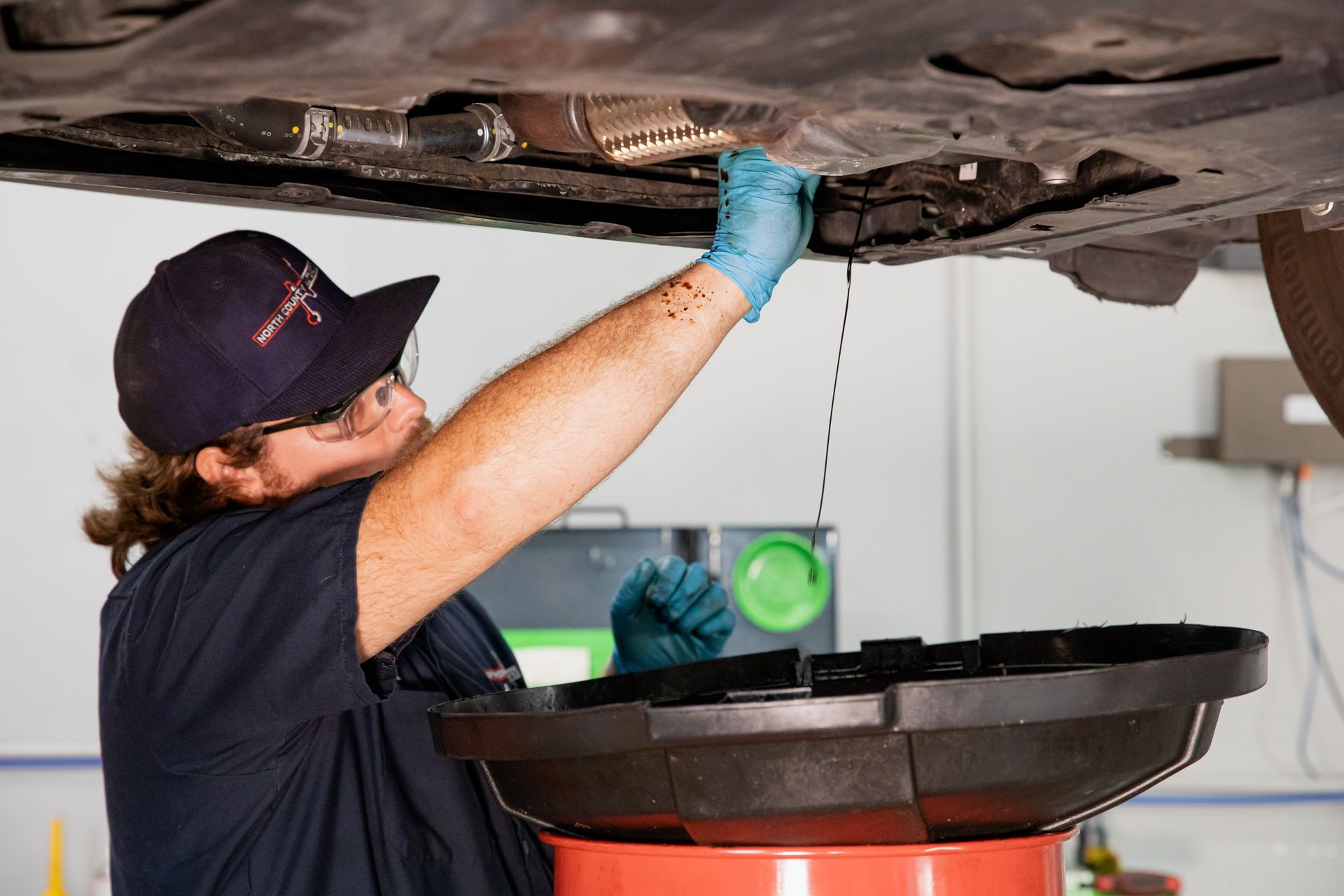 A man is working under a car in a garage.
