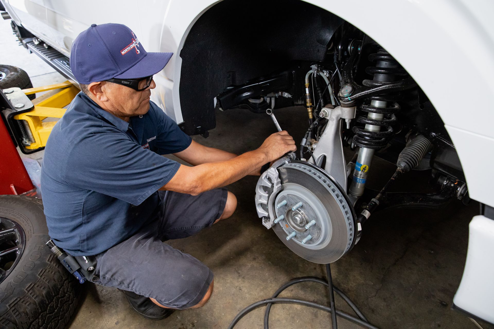 A man is working on the brake pads of a truck.