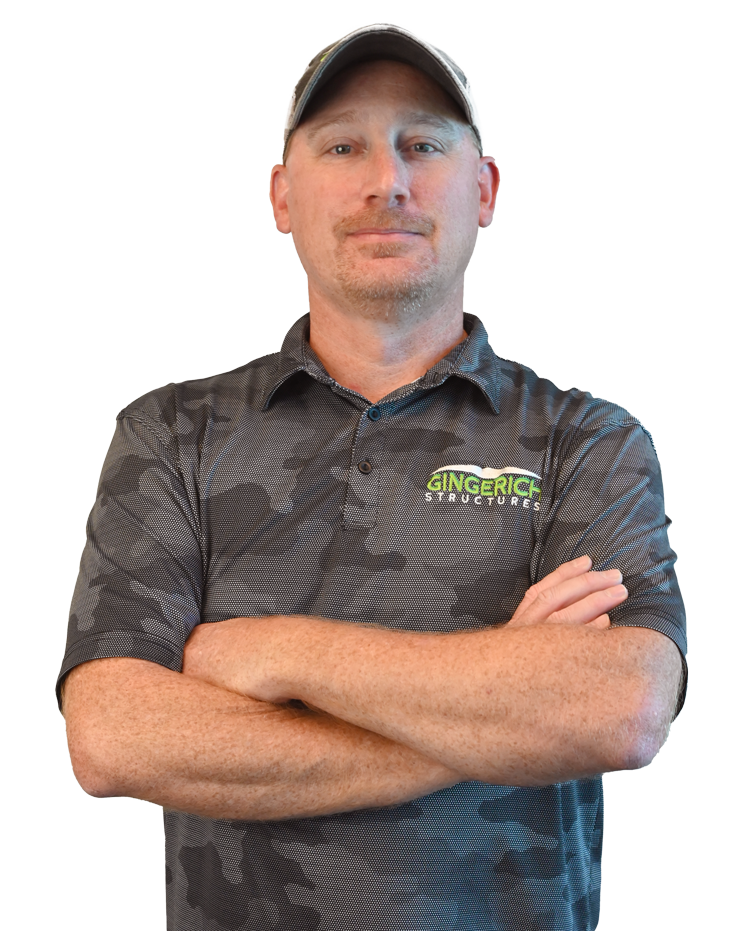 Man in a gray patterned polo and cap, standing against a white background with a slight smile.