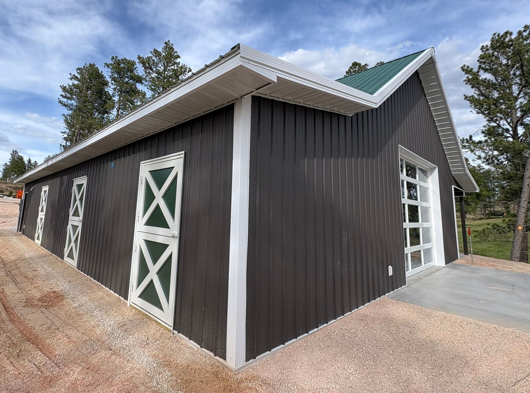 Post-frame shop building with covered breezeway and overhead garage door
