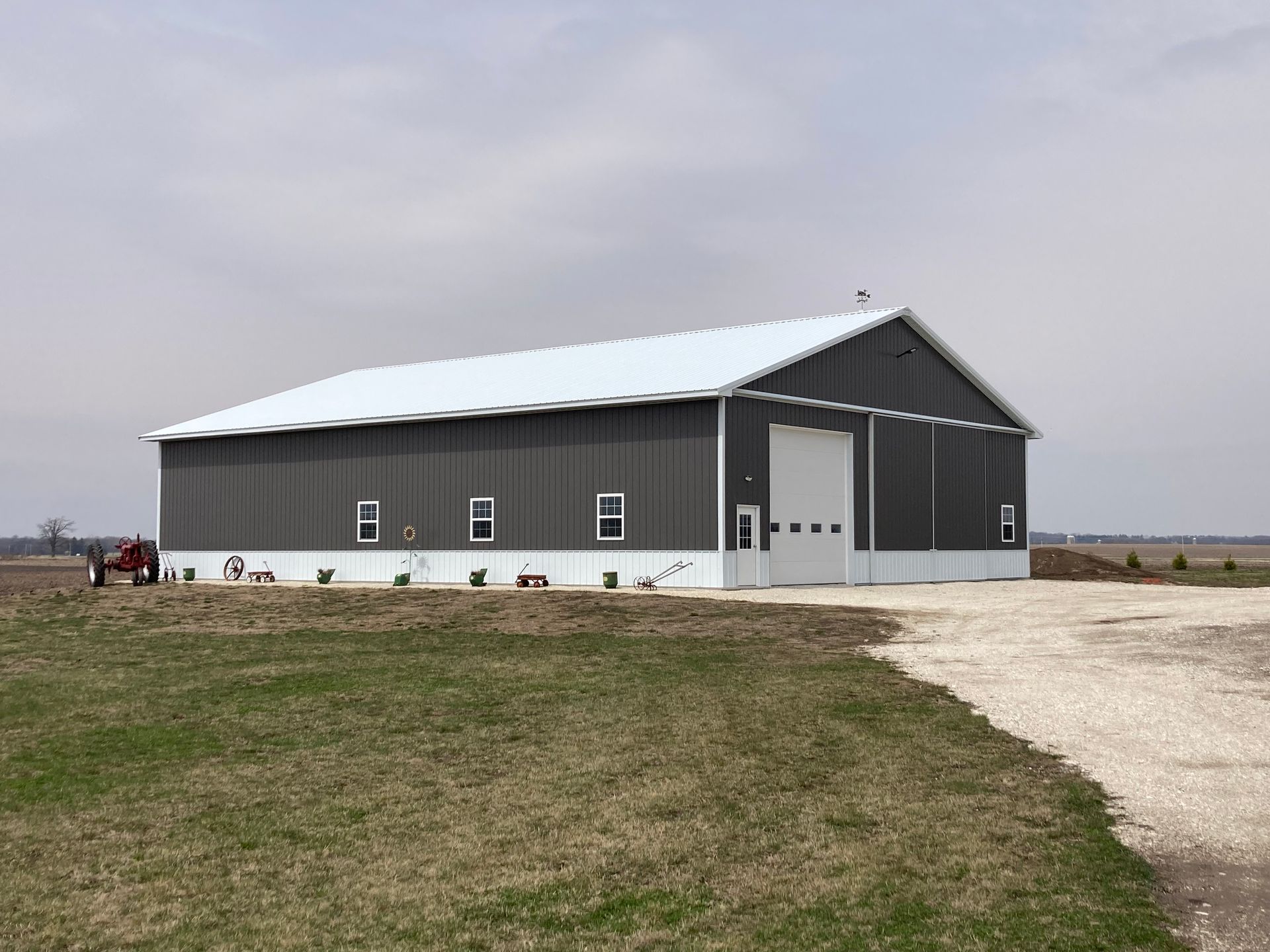 Red barn with white trim against a bright blue sky.