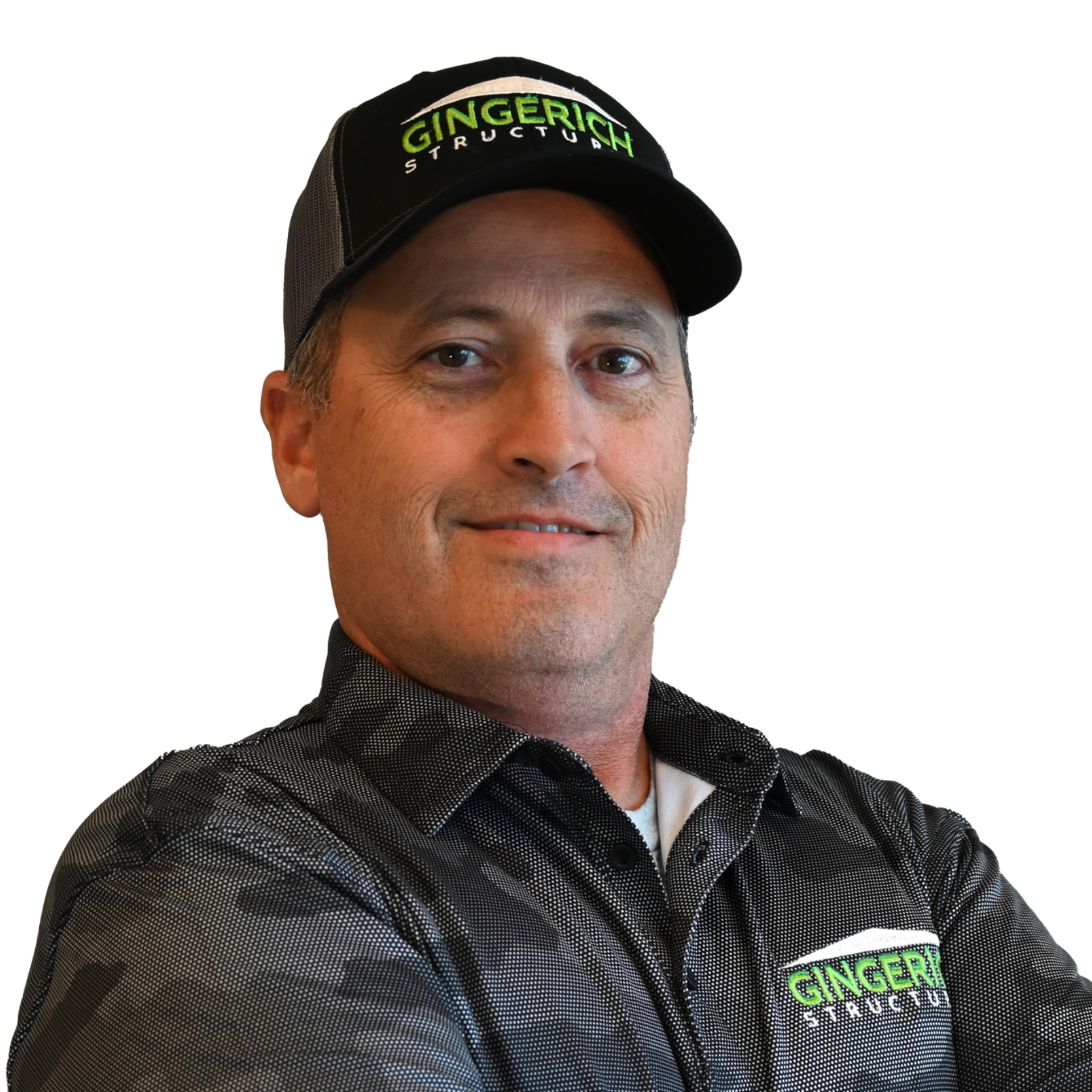 Man wearing a hat and patterned shirt smiles at the camera.