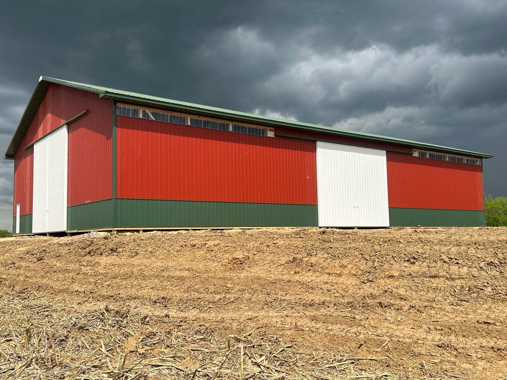 Modern metal garage with a wooden porch and a stone facade.