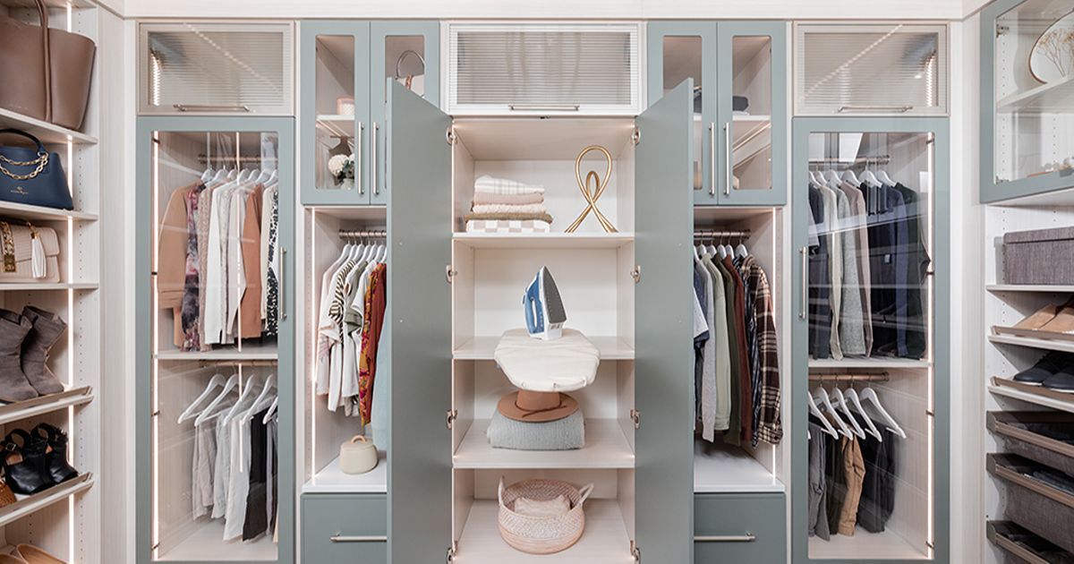 Walk-in closet with light blue cabinets, filled with clothes, shoes, and accessories.