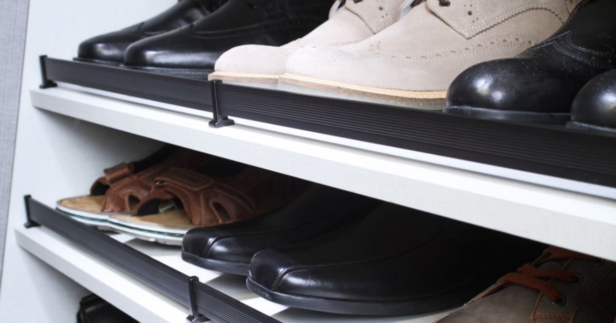 Shoe rack with multiple shelves holding various styles of shoes, including boots and sandals.