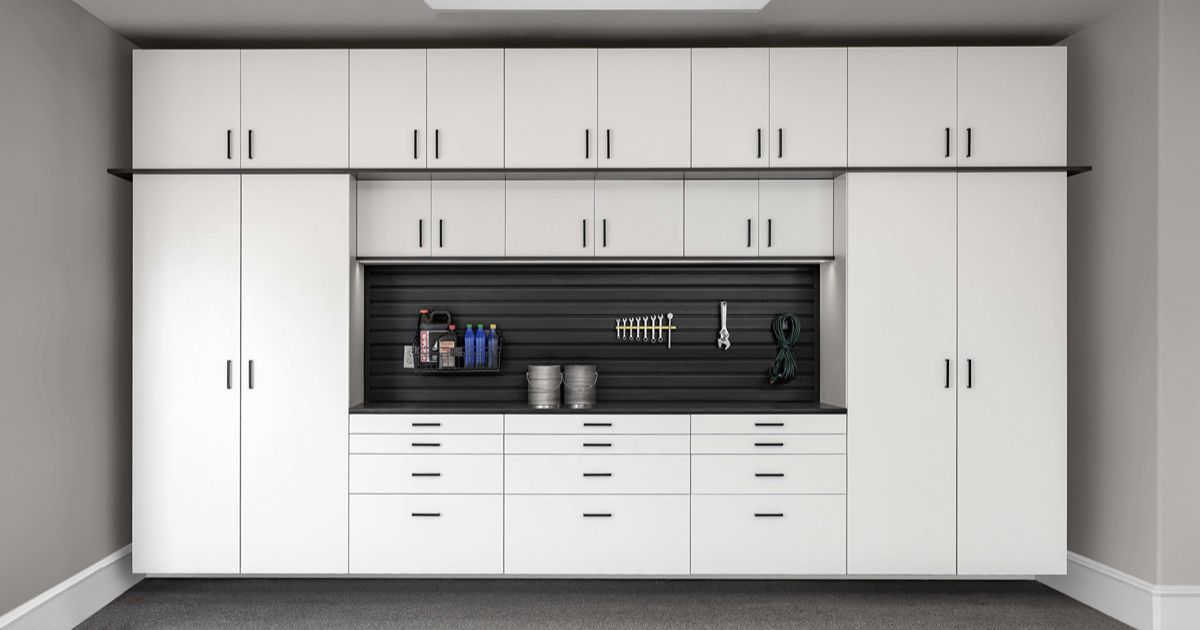 White garage cabinets with a black pegboard and countertop.
