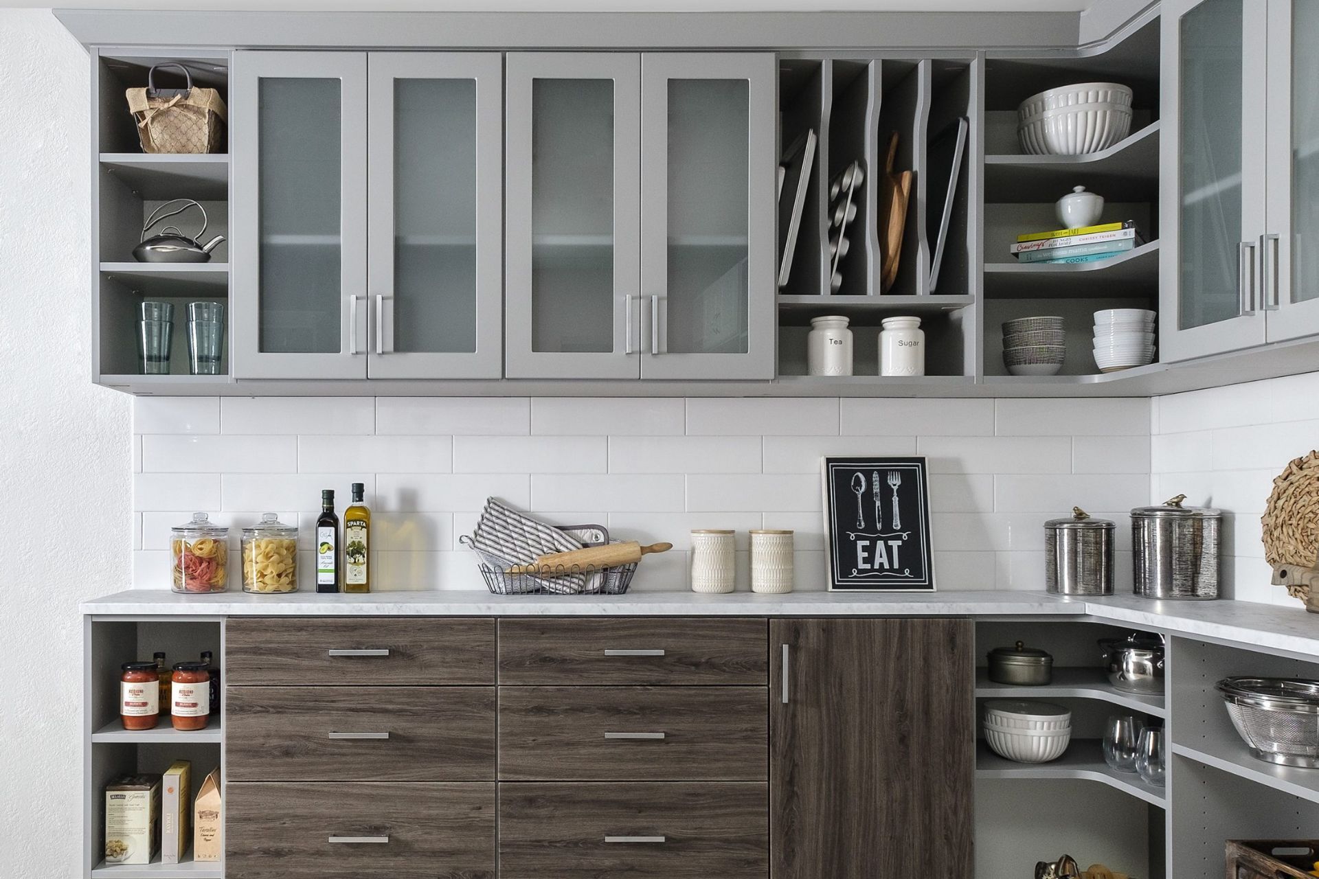 Modern kitchen cabinets and countertop with various stored items.