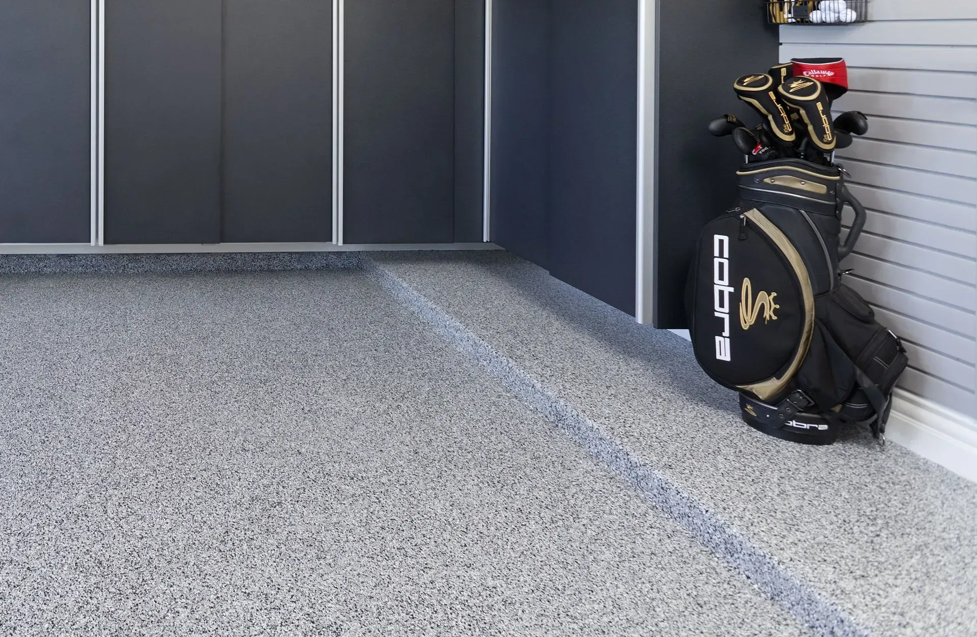 Motorcycle parked on interlocking gray and black garage floor tiles.