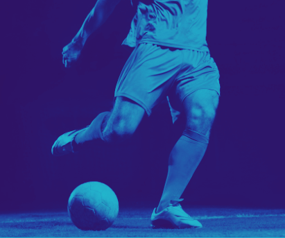 Soccer player dribbling a ball under blue-purple lighting