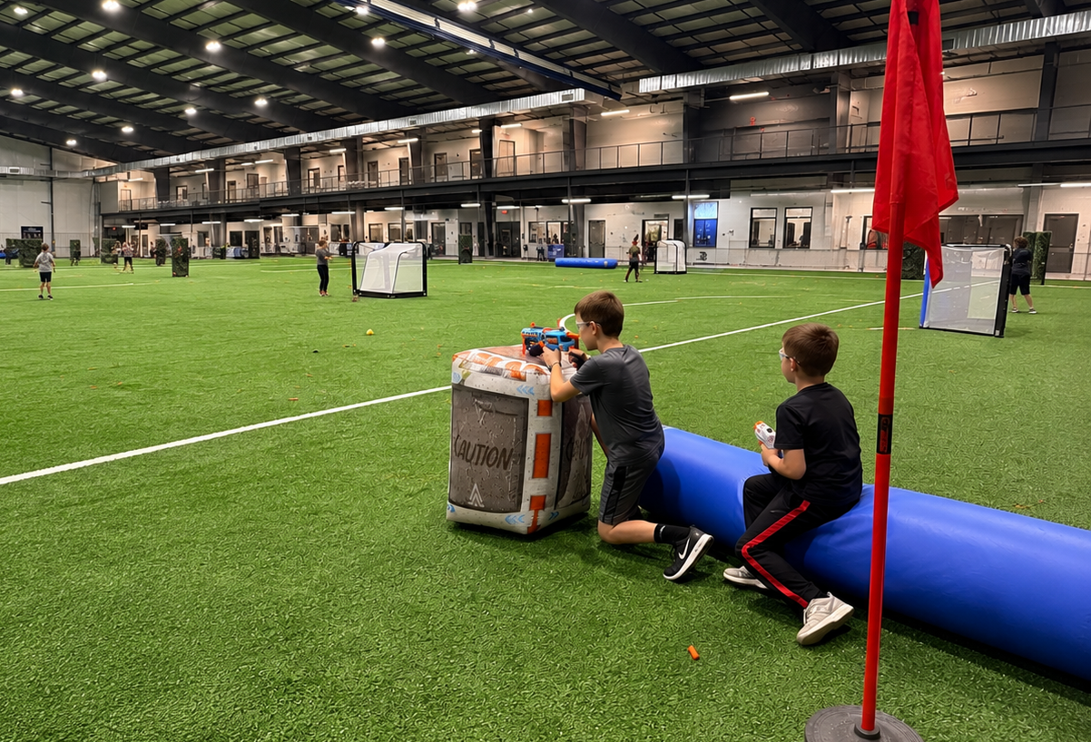 Indoor sports field with people crouching behind cover during an airsoft or paintball game