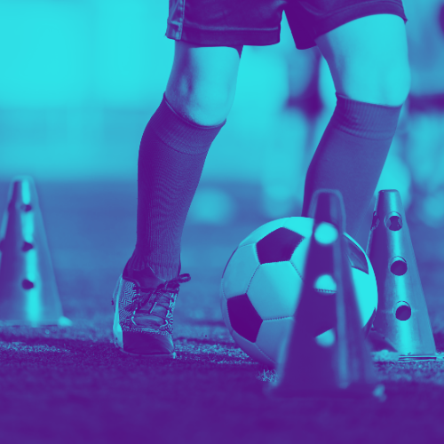 Soccer player dribbling a ball between training cones on a field, tinted blue and purple
