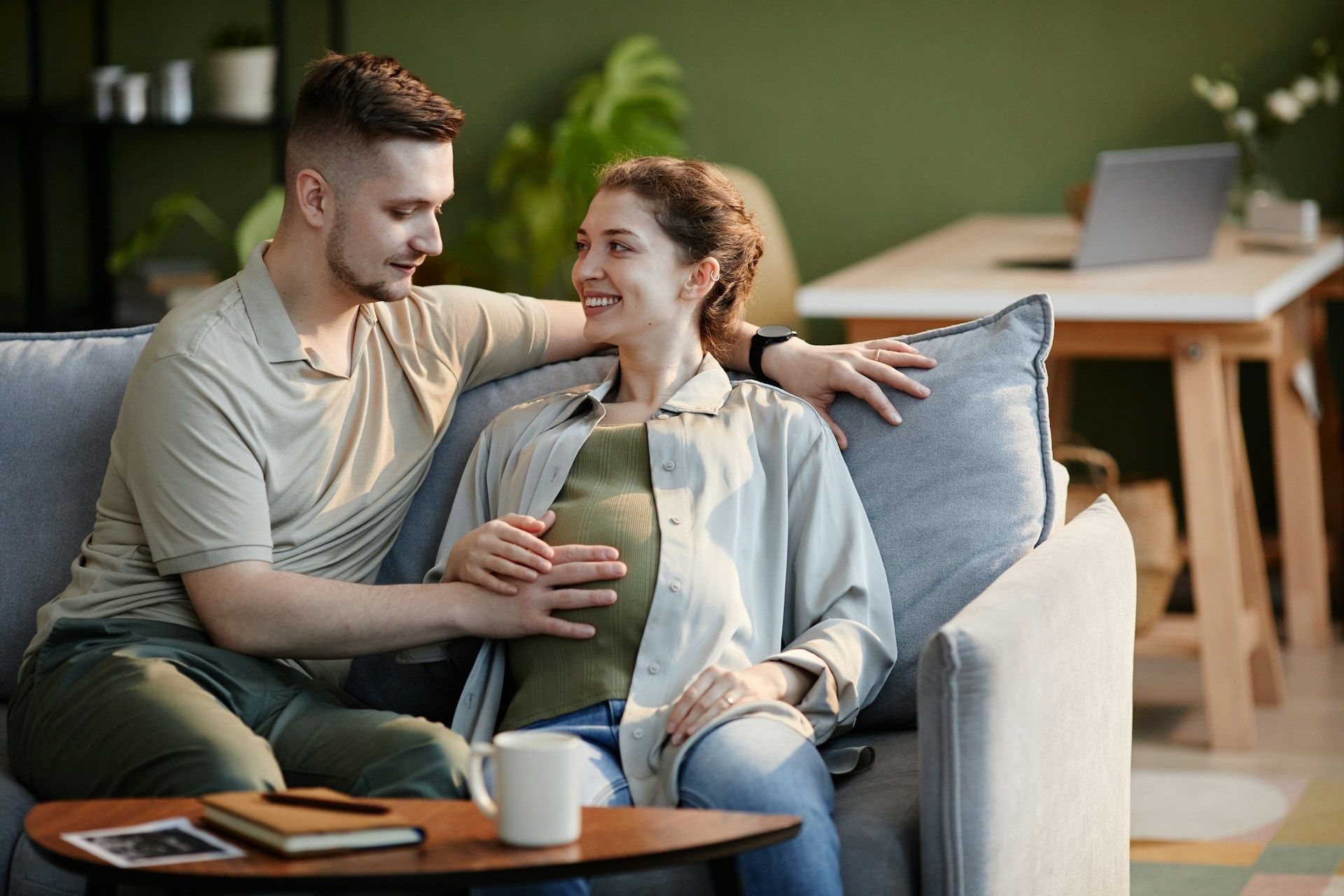A man and a woman are sitting on a couch with a child.
