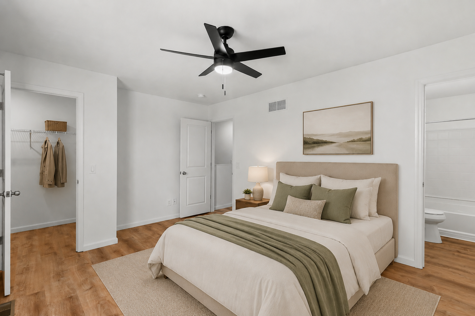 Bright bedroom with a bed, ceiling fan, wood floors, and open closet doors