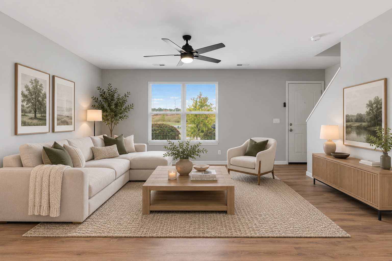 Bright, neutral living room with beige sofas, armchairs, wood accents, and large window views.