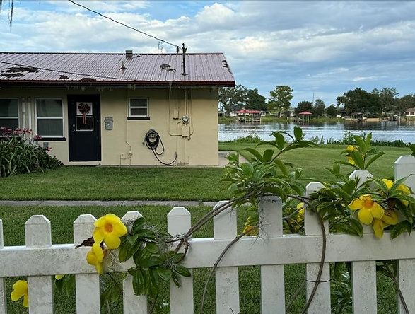 A white picket fence with yellow flowers in front of a house