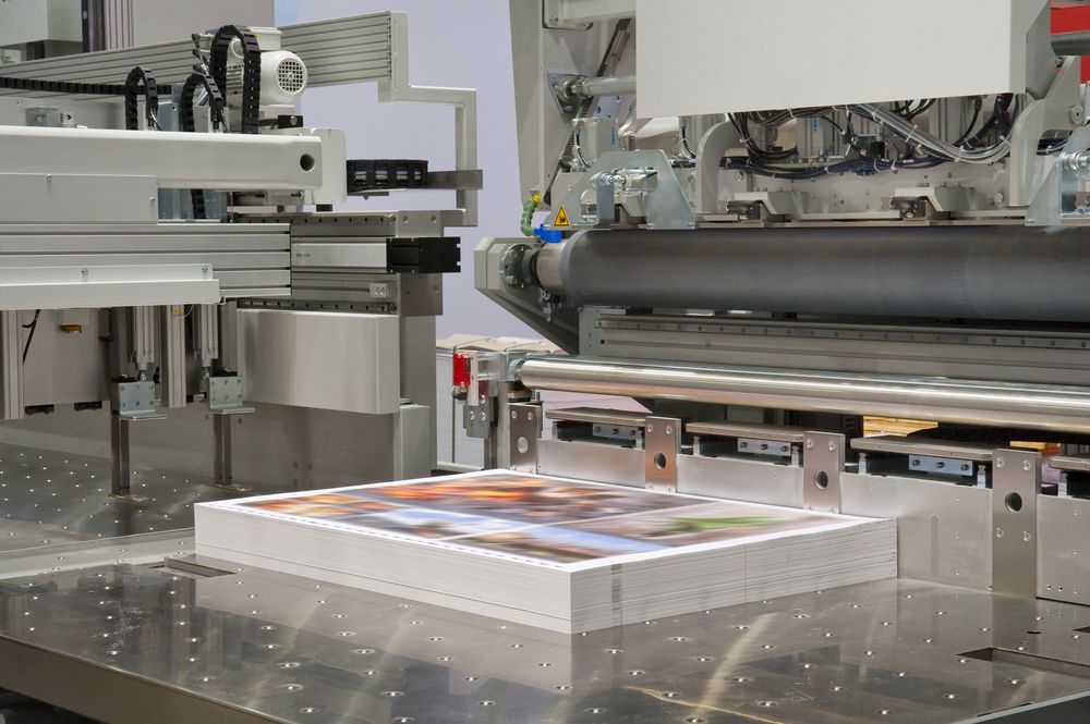 Printing Press With a Stack of Printed Sheets on a Metal Table — Lehmann Print Solutions in Bowen, QLD