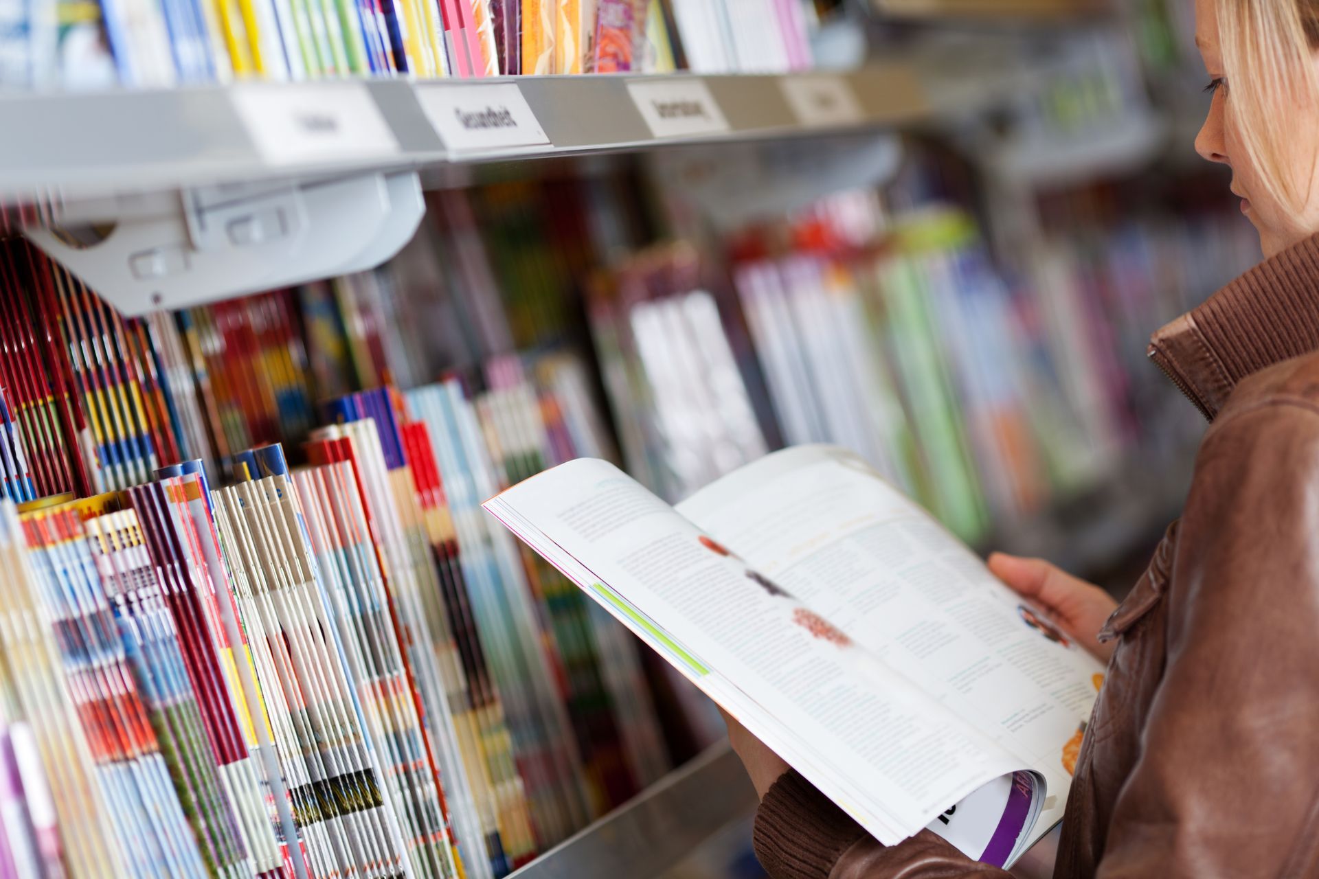 Person Reading an Open Book in a Bookstore Aisle — Lehmann Print Solutions in Bowen, QLD