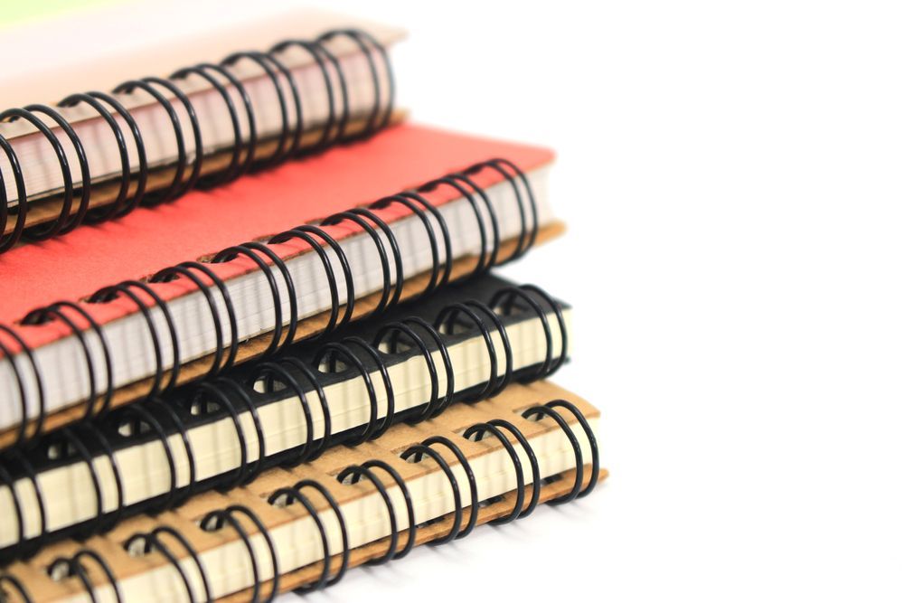 Stack of Spiral Notebooks in Pink, Black, and Tan on a White Background — Lehmann Print Solutions in Bowen, QLD