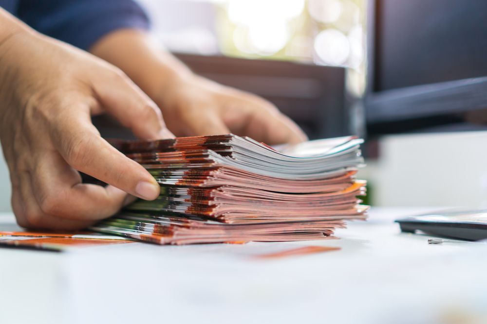 Hand Counting a Stack of Bundled Paper on a Desk — Lehmann Print Solutions in Bowen, QLD