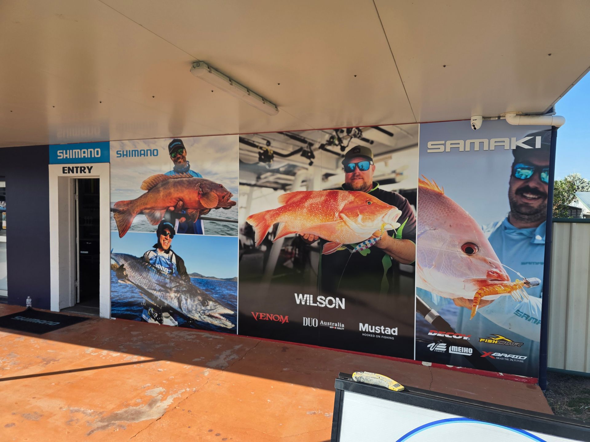 Fishing Storefront With Large Colorful Angler Posters — Lehmann Print Solutions in Bowen, QLD