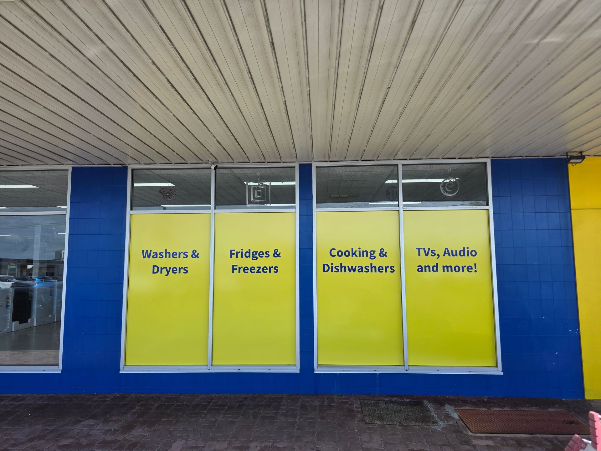Storefront Windows With Yellow Signs — Lehmann Print Solutions in Bowen, QLD