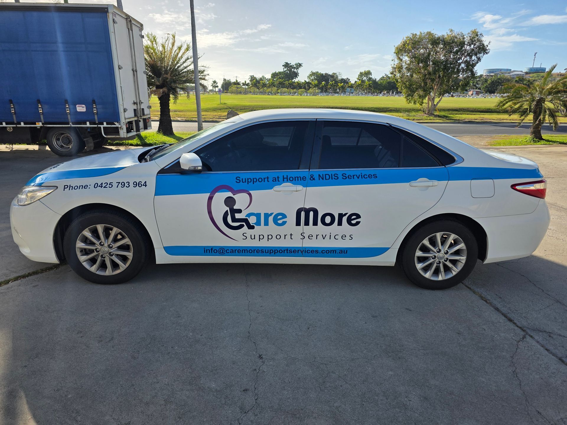 White Sedan With Care More Logo Parked on a Road — Lehmann Print Solutions in Bowen, QLD
