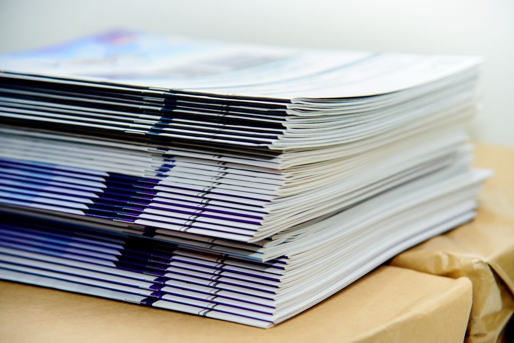 Stack of Neatly Bound Papers With Blue-striped Edges on a Cardboard Box — Lehmann Print Solutions in Bowen, QLD