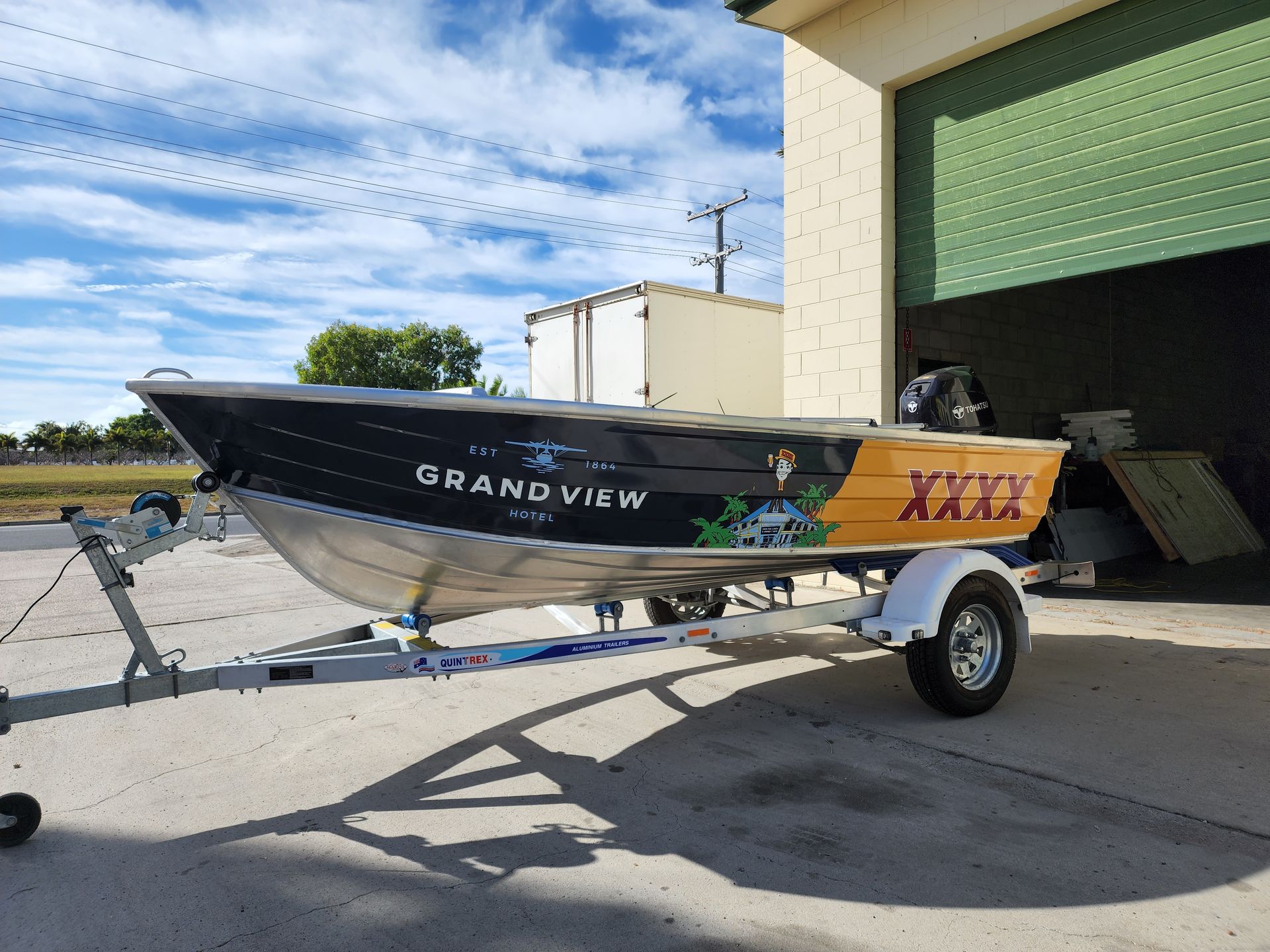 White-and-black Boat on a Trailer Outside a Warehouse — Lehmann Print Solutions in Bowen, QLD