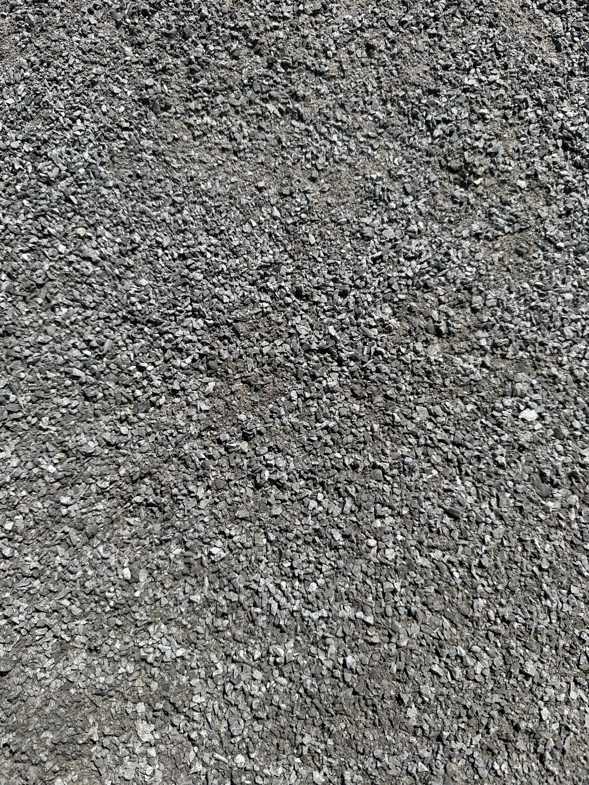 Close-up of rough gray gravel or asphalt surface texture