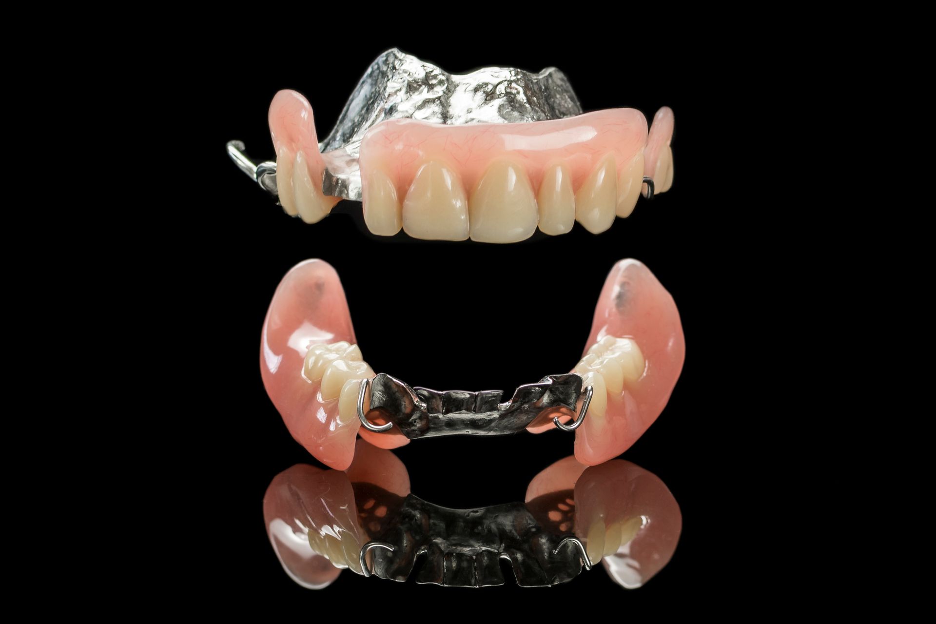 A close up of a pair of dentures on a black background.