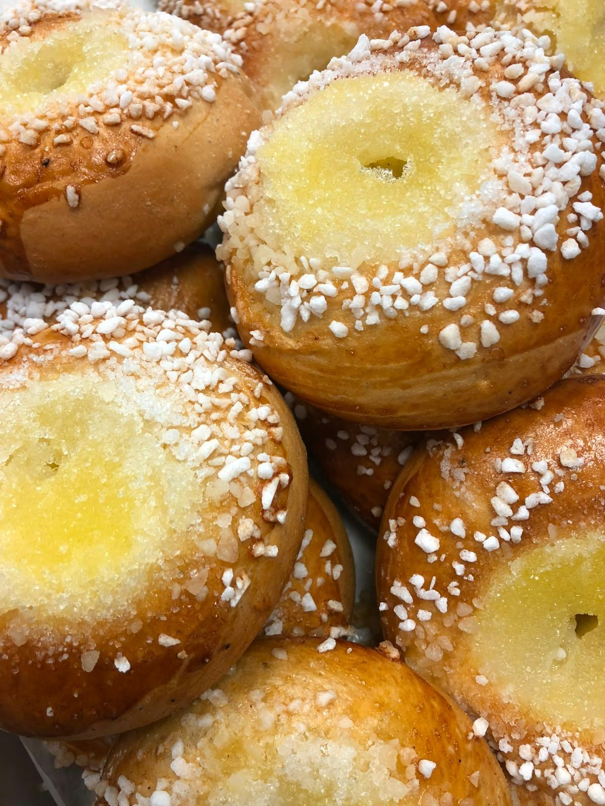Raesokerilla kuorrutetut, keltaisella keskellä olevat pullat, tiiviisti pinottuina