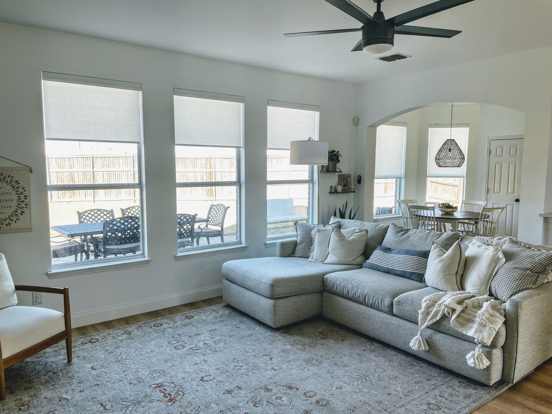 A living room with a couch , chair , and ceiling fan.