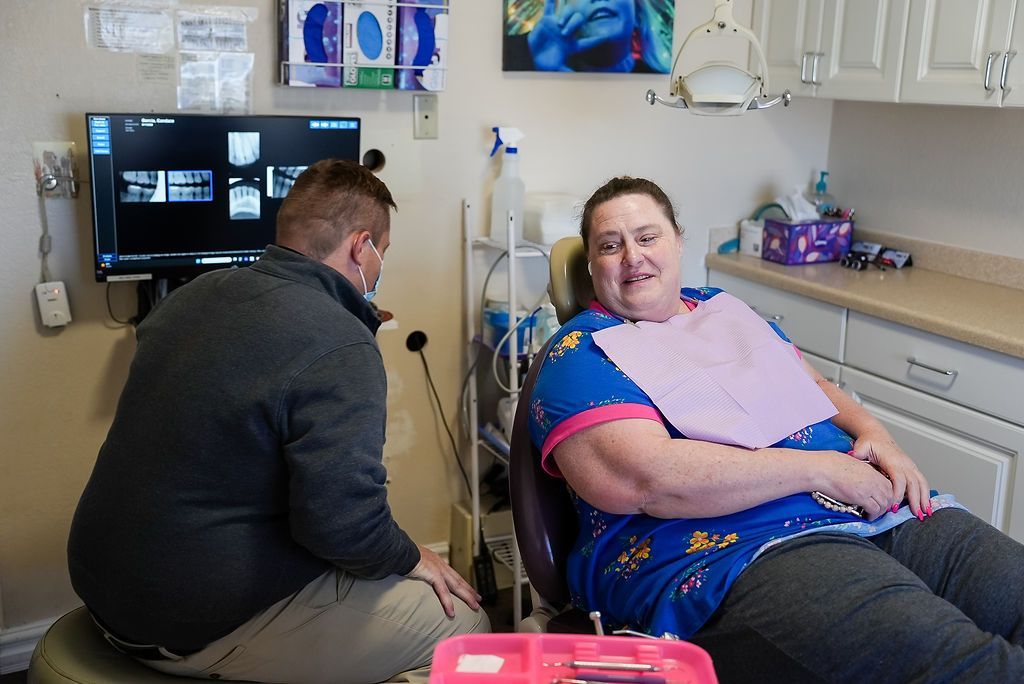 Two people in a medical room, one seated by a monitor