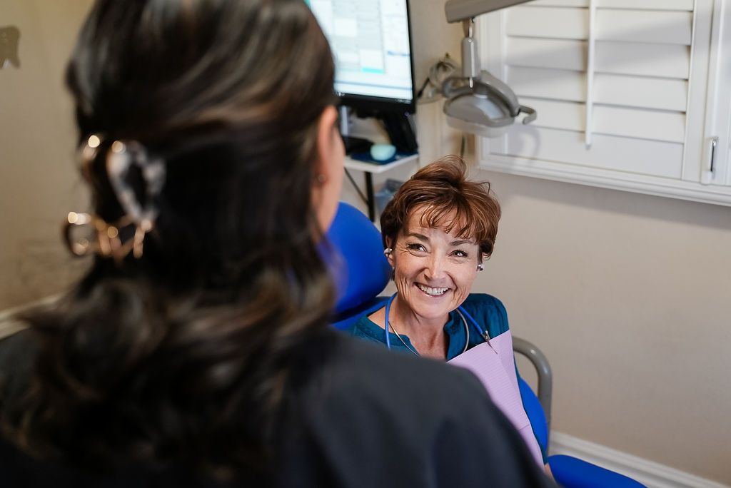Dentist smiling at patient in exam chair during dental checkup
