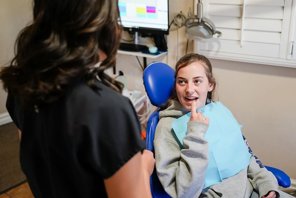 Patient smiling in a dentist chair while a clinician stands nearby