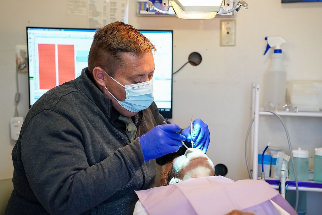 Dentist wearing mask and gloves treats a patient in a dental clinic.