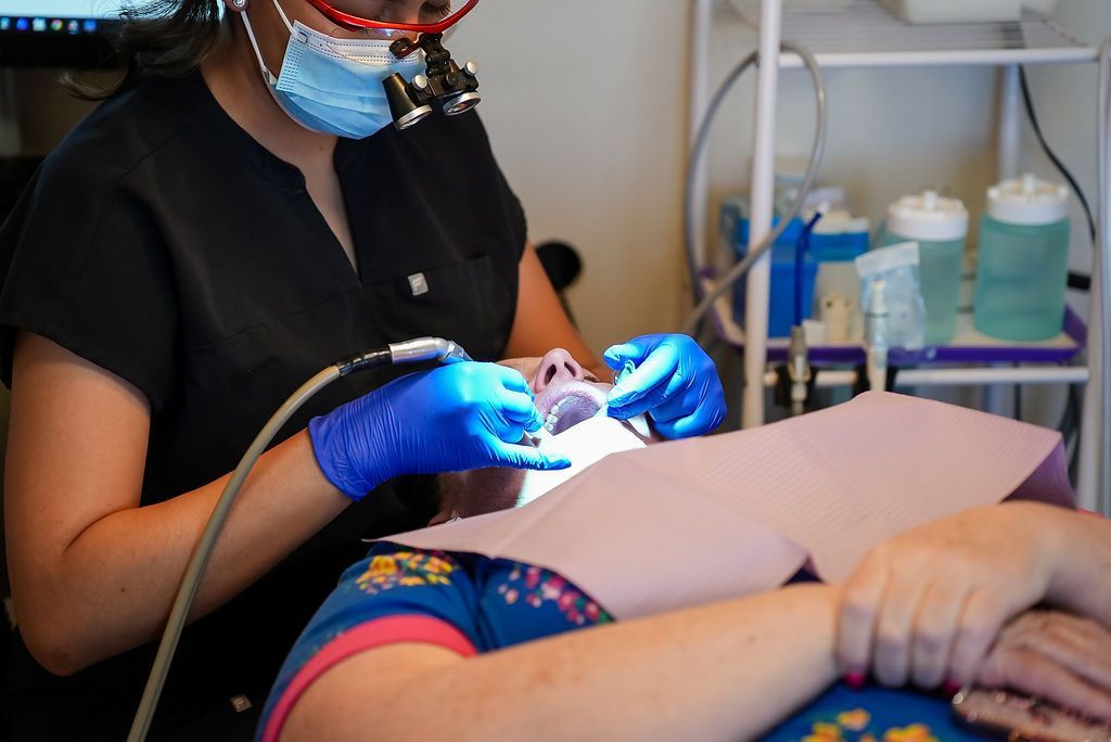 Dentist using a blue light on a patient in a dental chair